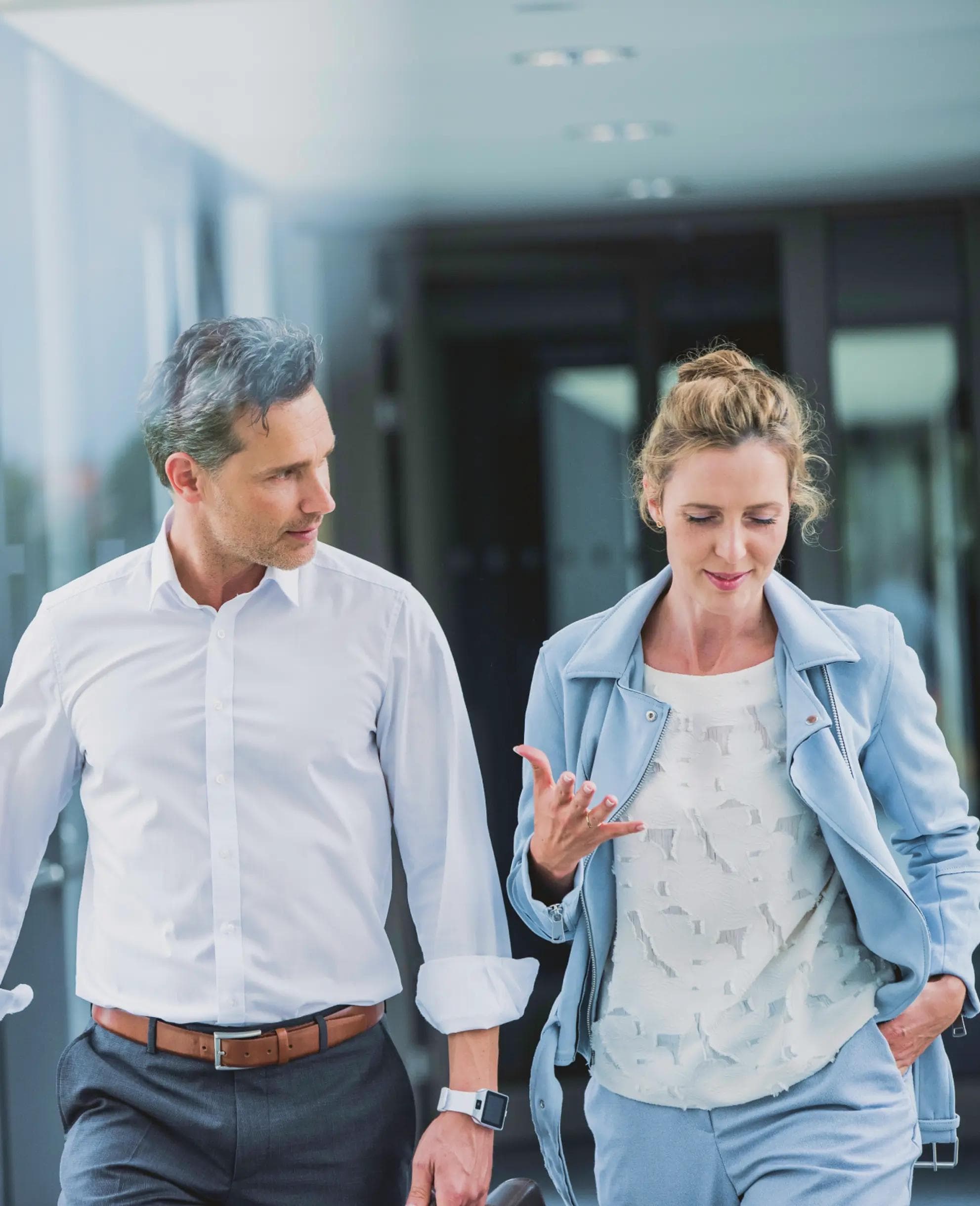 Um homem e uma mulher andando por um corredor.