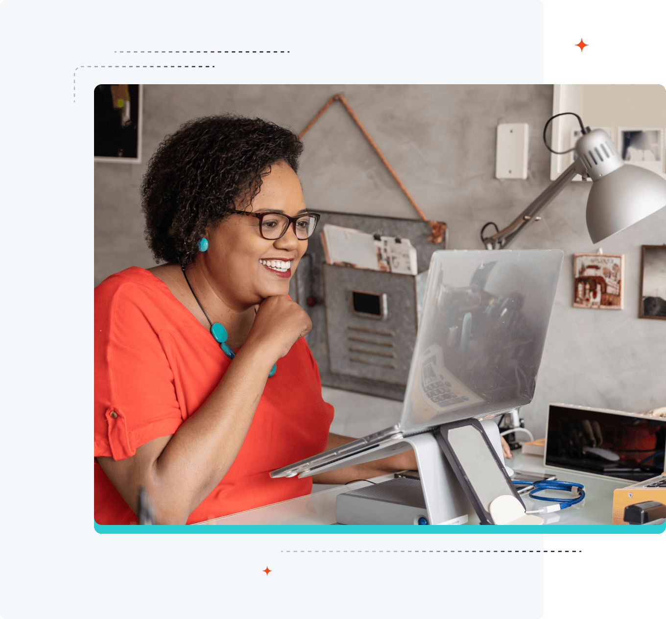 Imagem de uma mulher sorridente olhando para o laptop que está em um suporte elevado.