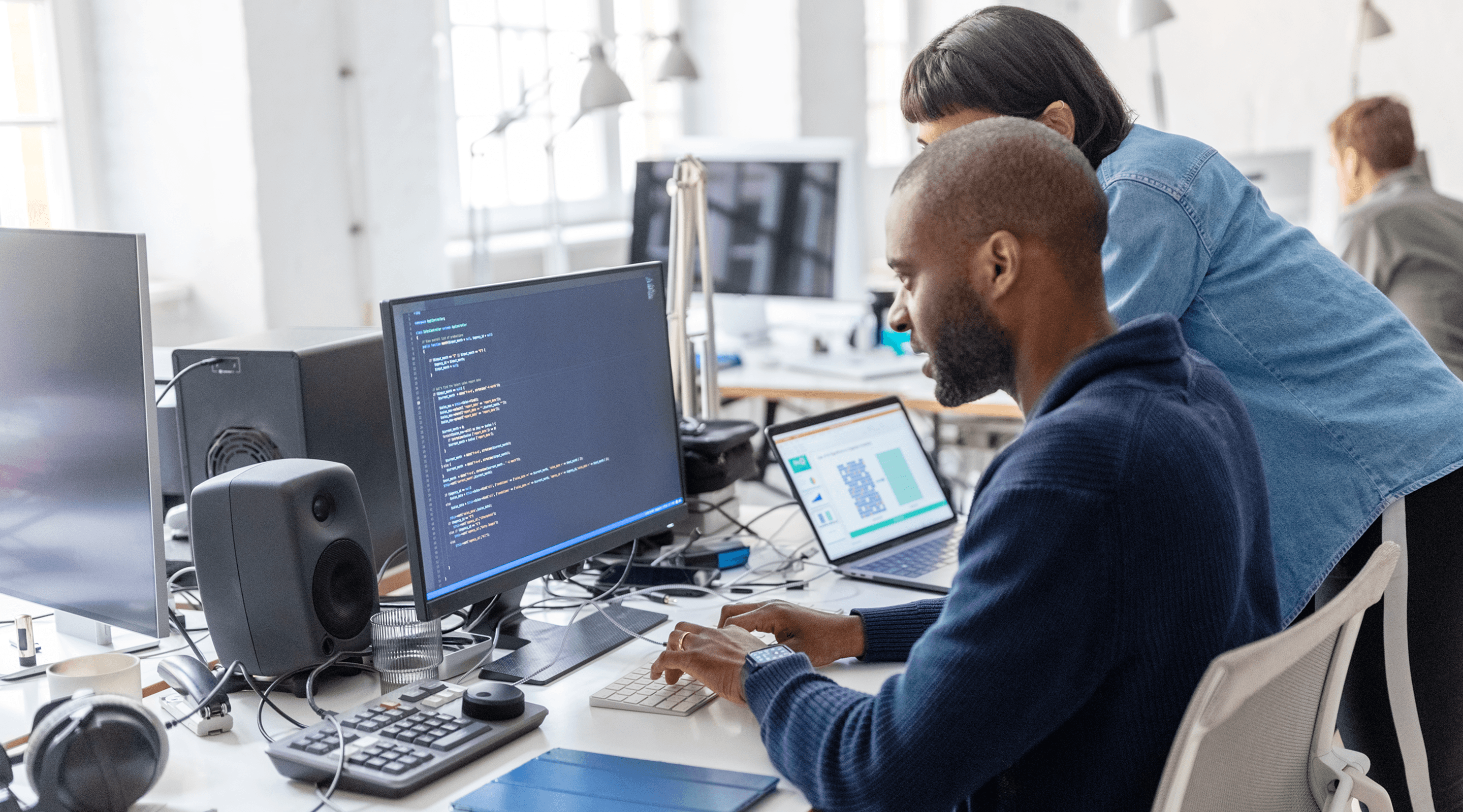 A woman sits in front of a laptop with 65% complete on the screen.