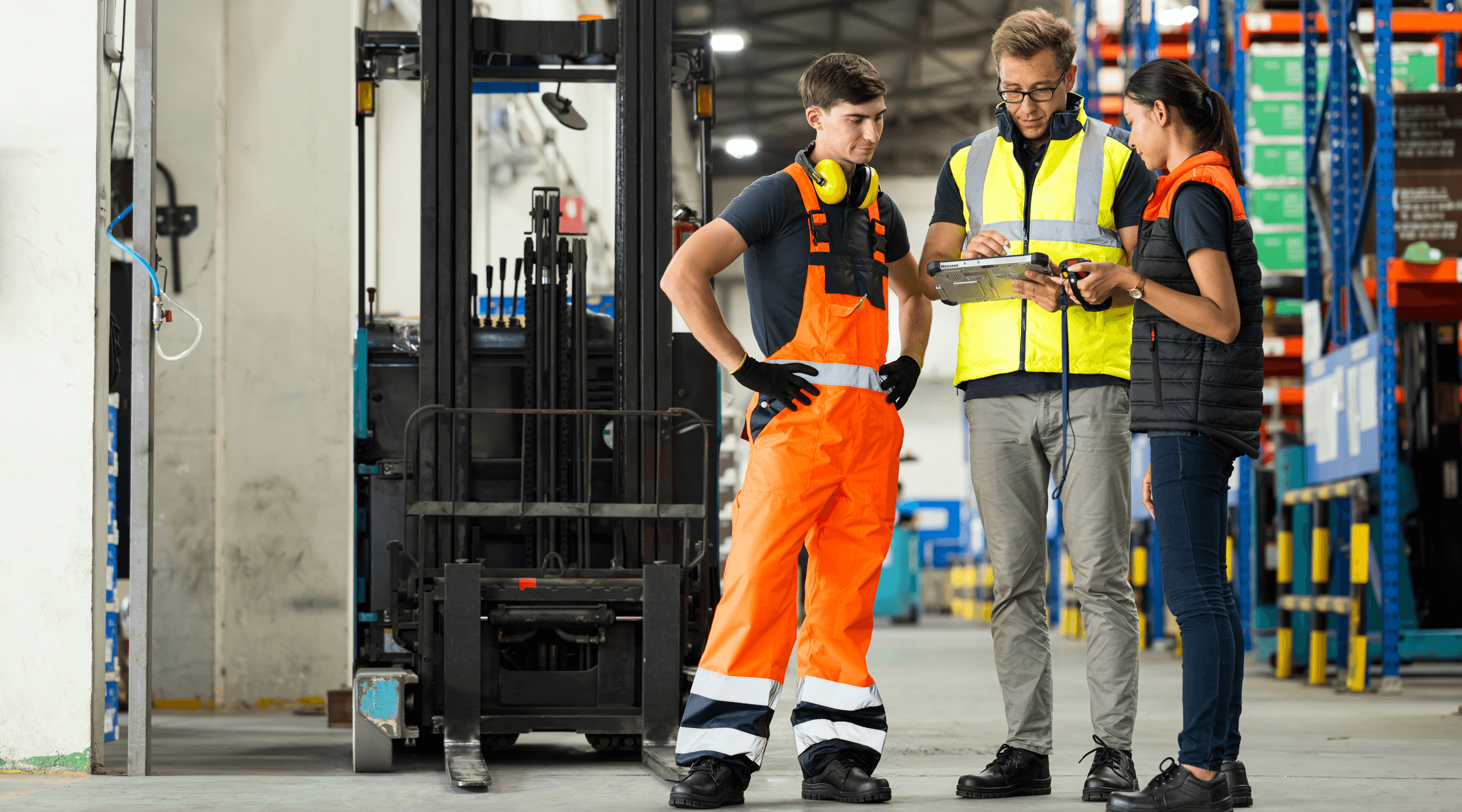 three industrial workers looking at a mobile device.