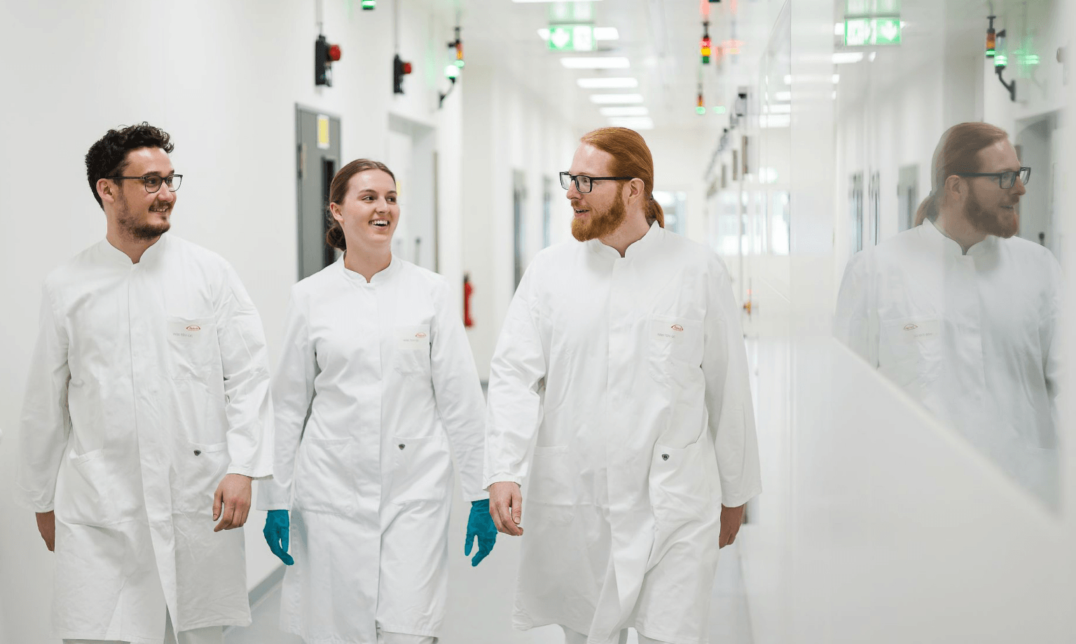 3 Takeda employees walking down a hallway.