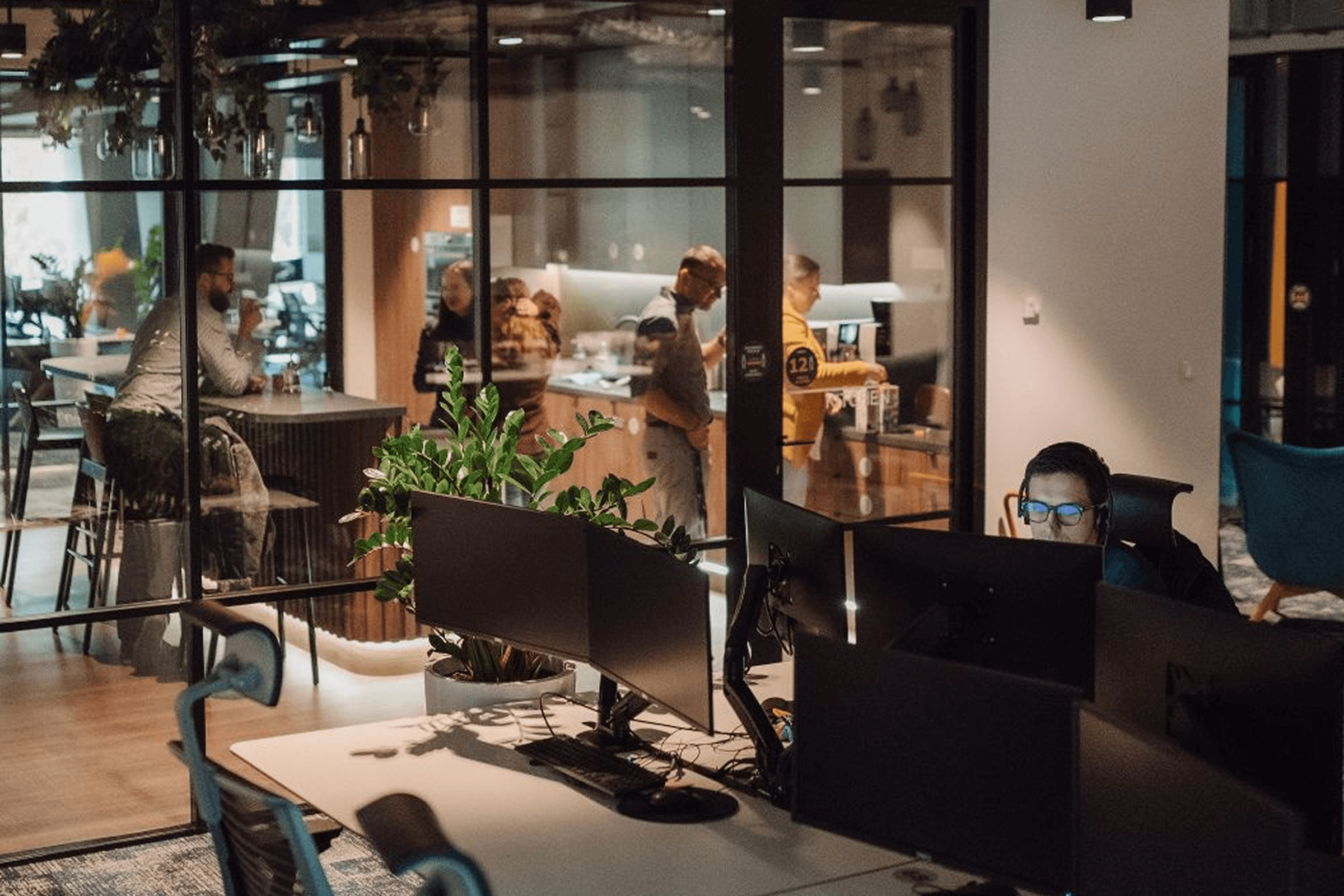 a man sitting in front of a computer with a yellow shirt that says ' a ' on it